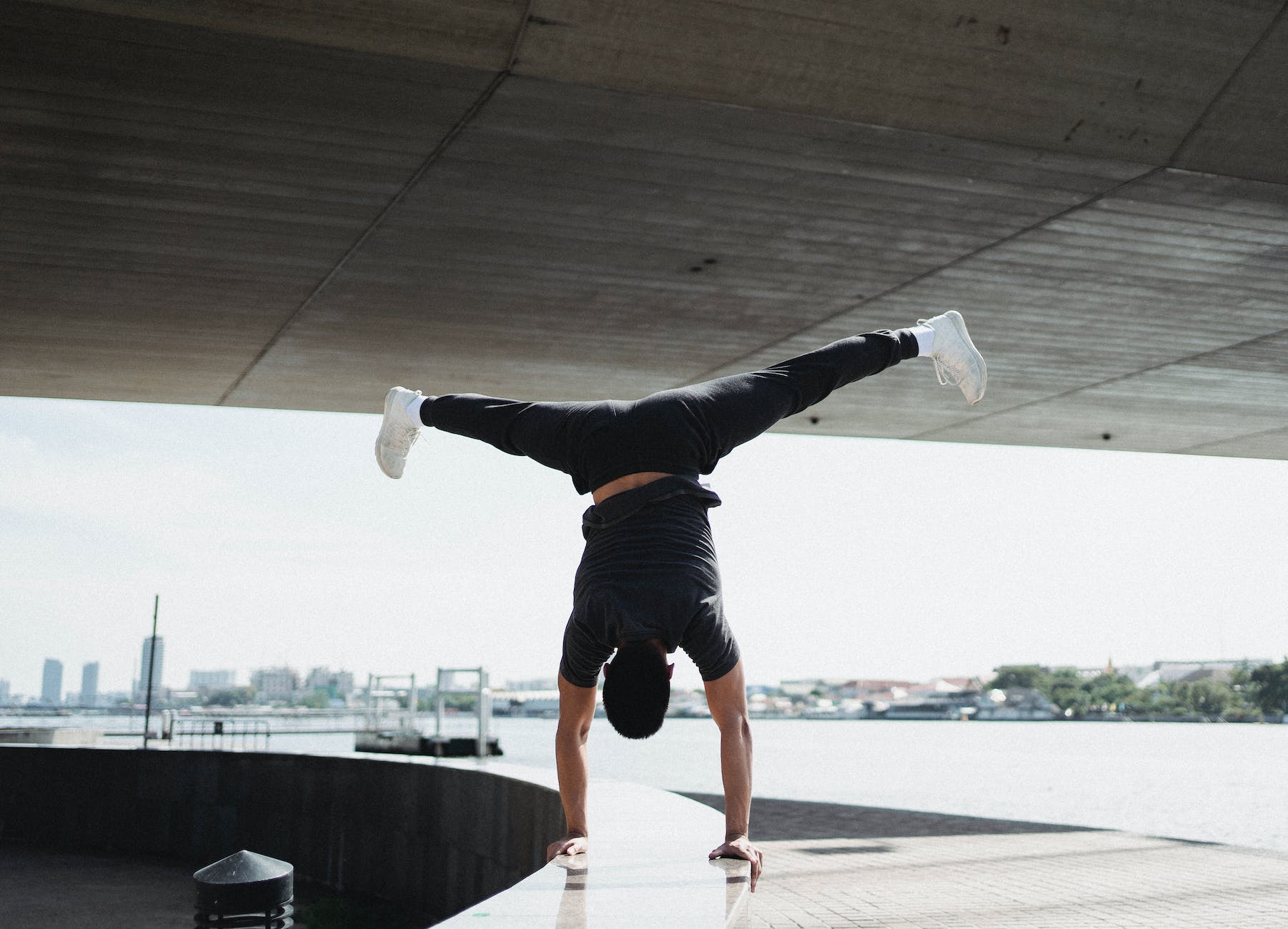 faceless sportsman doing handstand and split in air